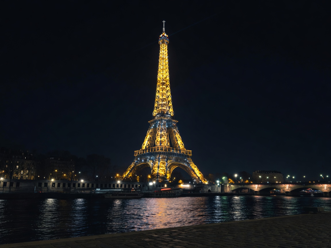 Eiffel Tower glittering over Seine at midnight in Paris